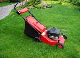 Image of a red lawnmower on grass